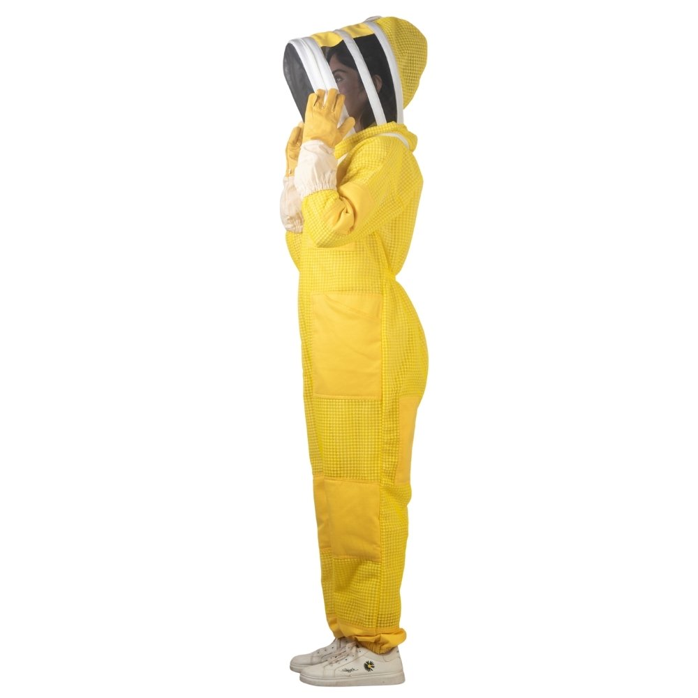 Side profile of yellow beesuit showing beekeeper adjusting protective veil with gloves
